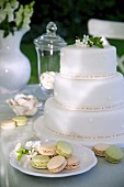 White, multi-tiered wedding cake and macaroons