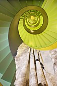 Illusion eines spiralförmigen Treppenauges in Gelbgrün-Tönen mit aufgehängtem Tuch