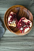 Pieces of pomegranate and a wooden bowl (seen from above)