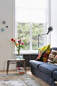 Sofa with patterned scatter cushions, retro standard lamp and side table on Oriental rug