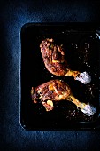 Slowroasted duck legs on a baking tray