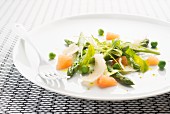 A spring salad with asparagus, parmesan, peas, grapefruit and green tomatoes