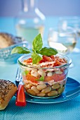 White beans with salmon and basil in a jar