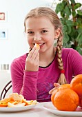 A girl eating an orange