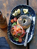 A poppyseed bagel with smoked salmon, capers and onions