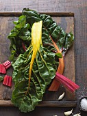 Colourful chard leaves on wooden chopping board