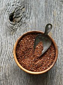 Red quinoa in a wooden bowl with a scoop