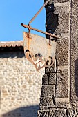 Metal sign hanging on a building in the Citadel of Carcassonne (France)