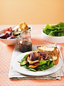 Warm salad of oven vegetables on spinach with pita bread