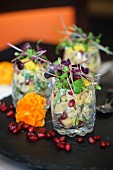 Fruity potato salad in glasses with pomegranate seeds and mixed bean sprouts
