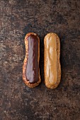 Zwei Éclairs mit Schoko- und Kaffeeglasur auf einem Backblech