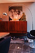 Retro arc lamp in front of small Christmas tree on top of wooden sideboard with metal frame