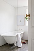 Freistehende Badewanne im Vintage Stil auf Estrichboden in weißem Badezimmer