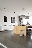 Pale wooden desk below modern pendant lamps in designer interior