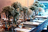 Elegant gedeckter Tisch mit üppigen, weissen Blumensträußen