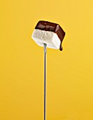 A chocolate dipped marshmallow on a fondue fork
