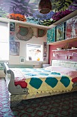 Buntes Schlafzimmer in Mustermix: Ornamentteppich, Blumentapete an der Decke und Quilt auf dem Bett