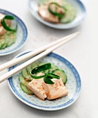 Tofu with sesame seeds and ginger on a bed of cucumber slices