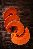 Pumpkin wedges on a wooden surface