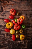 Various types of tomatoes on a wooden surface