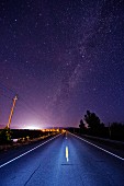 An empty street under a magnificent starry sky