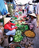 Frauen mit konischen Hüten verkaufen Obst und Gemüse im belebten Zentralmarkt, Hoi An, Zentral-Vietnam, Vietnam, Indochina, Südostasien, Asien