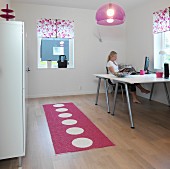 Home office with two desks and filing cabinet in plain white combined with polka-dot runner, plexiglass lampshade and floral blinds in pink