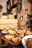 Mini cheese quiches, a selection of cheese and wine in a delicatessen