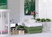 Ablage im Bad mit Handtüchern und Badutensilien vor Spiegel