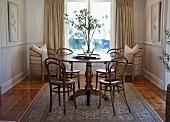 Thonet coffee-house chairs at round table in traditional-style living room