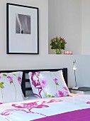 Bettwäsche mit Blumenmotiven auf Doppelbett, Kopfteil aus dunklem Holz in modernem Schlafzimmer