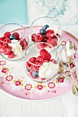 Raspberries and blueberries with cream cheese in glasses