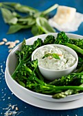 A basil and Pecorino dip served with broccoli florets and asparagus