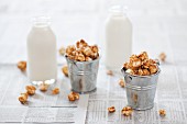 Small buckets of caramel popcorn and bottles of milk