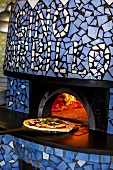 A pizza margherita being push into an oven (Pizzeria Sorbillo, Naples, Italy)
