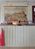 Colourful illustration above rustic, wood-clad kitchen counter
