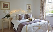 Wrought iron bed decorated with fairy lights in simple bedroom