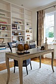 Postmodern desk with curved legs in front of white fitted shelving