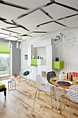 Chairs with perforated seats at round table on castors in airy interior