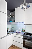 Shelves above corner sink in white fitted kitchen