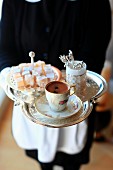 A waitress serving coffee with Turkish delight