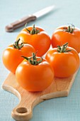 Orange tomatoes on a wooden chopping board