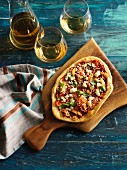 A rustic pizza and white wine