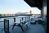 Spacious balcony with combination of outdoor furniture and view of cruise ship on river