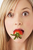 A girl eating a strawberry