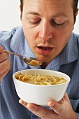 A man eating chicken noodle soup