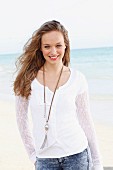 A young woman wearing a white lace cardigan over a white T-shirt