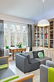 Elegant library with grey sofas, table with drawers and white Panton chairs in comfortable period interior