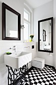 Sink on vintage sewing machine frame in bathroom with black and white chequered floor