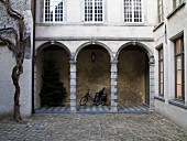 Cobbled courtyard with arcades on ground storey of traditional Flemish town house